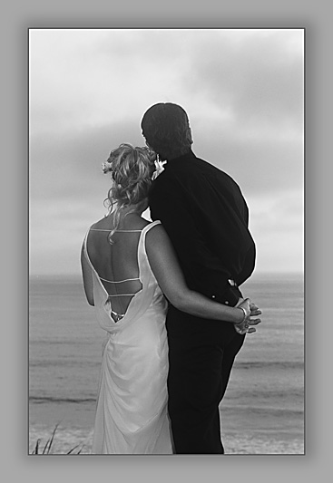 A newly married couple looking off toward the horizon at Del Mar, California